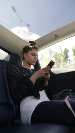 adolescente usando el teléfono en un coche