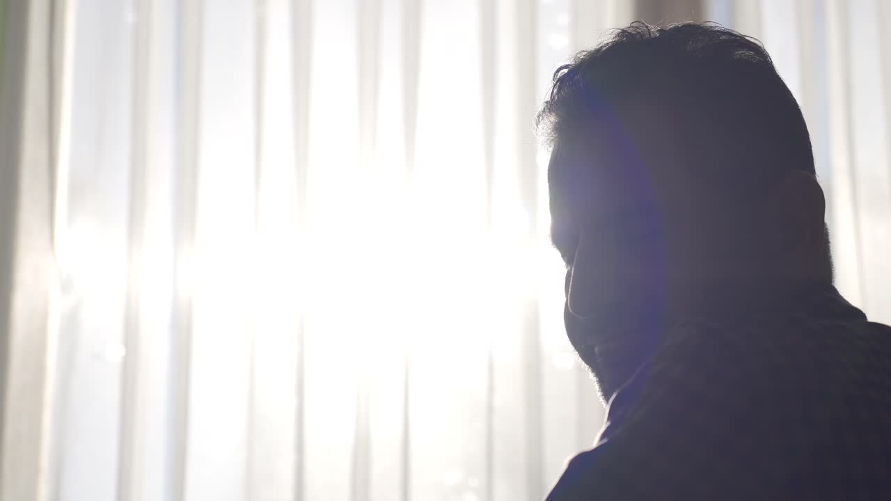 창문 밖을 바라보는 사려 깊은 성숙한 남자가 슬프고 사려 깊은 우울함을 느끼고 있습니다.