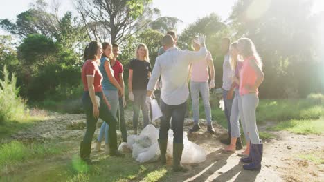 mid adults volunteering and cheering up during river clean-up day