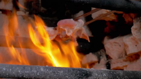 toma manual de tocino cocinado a fuego enorme mientras el chef lo toma por el otro lado para darle un sabor crujiente