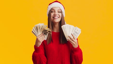 young woman with santa hat excited about money
