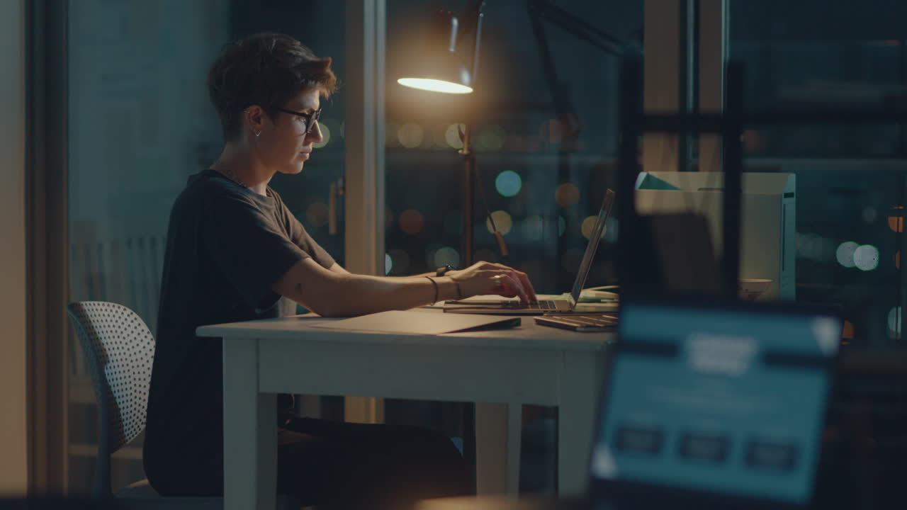 Donna che lavora al laptop in ufficio a tarda notte