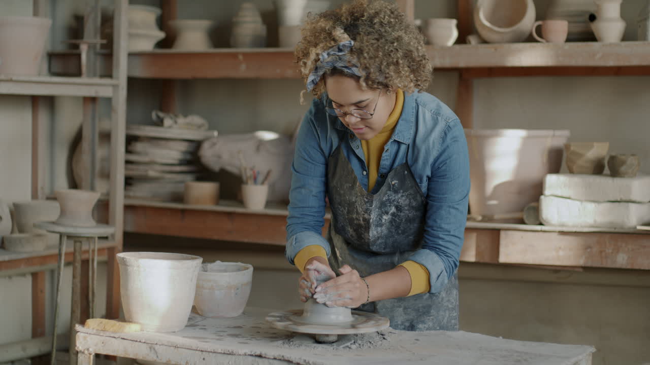 Woman Shaping Clay on Pottery Wheel in Workshop