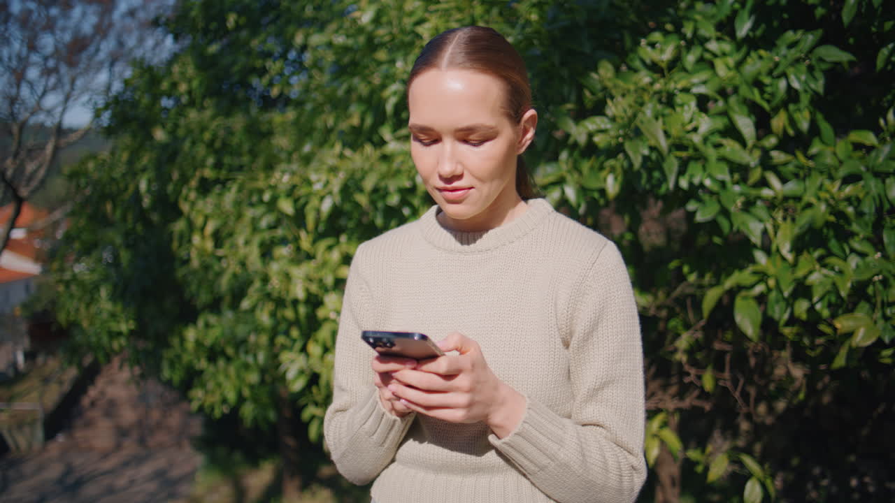 Worried girl using smartphone standing sunny city closeup. Lady typing message