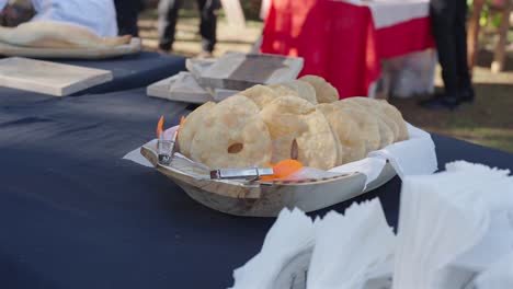 traditional argentine tortas fritas are arranged on a tray lined with napkins at an outdoor event, captured in slow motion to highlight texture and golden color under gentle natural daylight