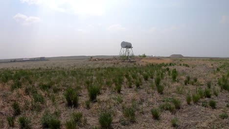 old water tower in the middle of a field in alberta canada on a cloudy day.