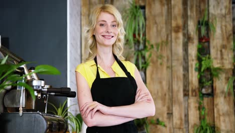 portrait of waitress standing with arms crossed at counter