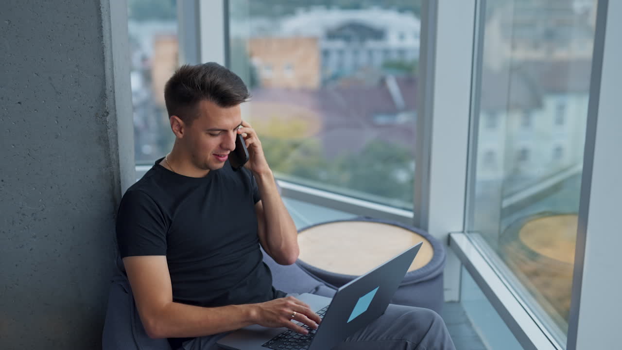 현대 사무실 에서 노트북 을 사용 하고 전화 를 사용 하는 사람