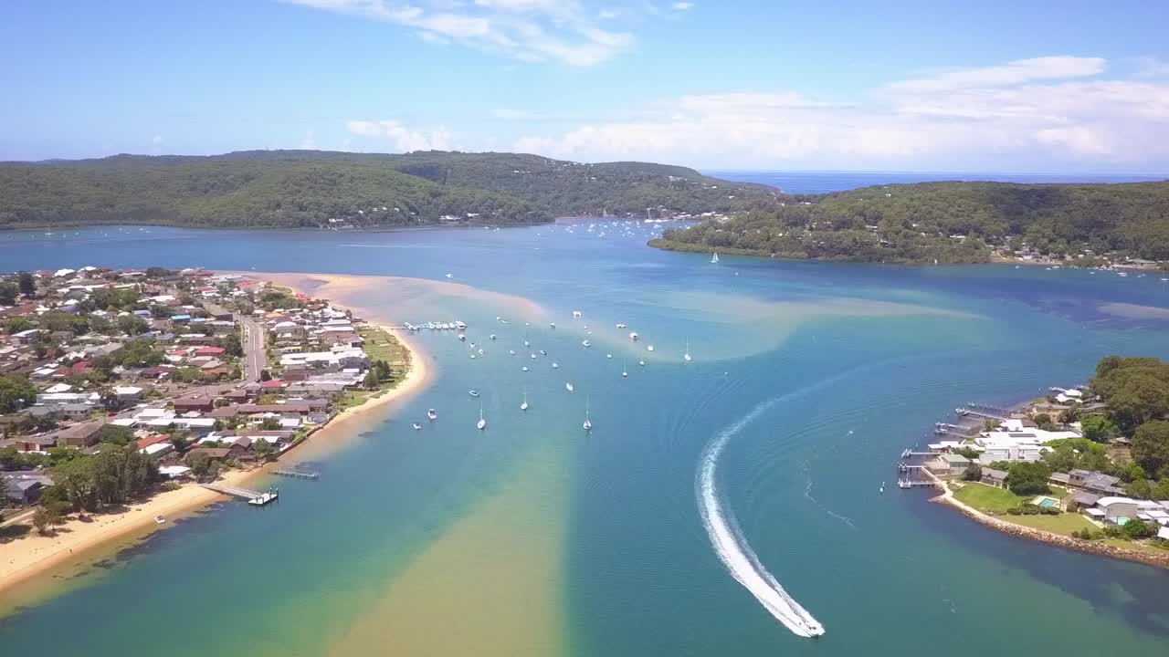 Aerial view of tropical white sand beach and turquoise clear sea water with waterfront houses and boats