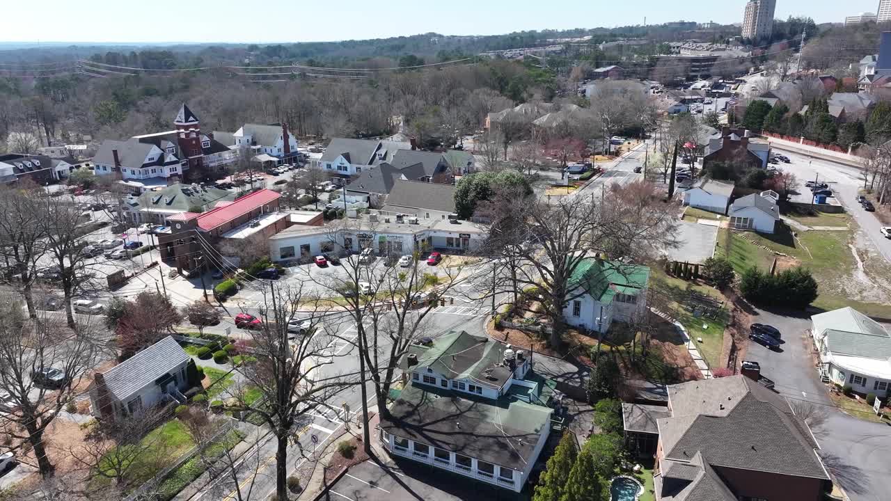 Vinings village in sunny daylight surrounded by urban park trees, Paces Ferry Road intersection, Atlanta, Georgia, Aerial