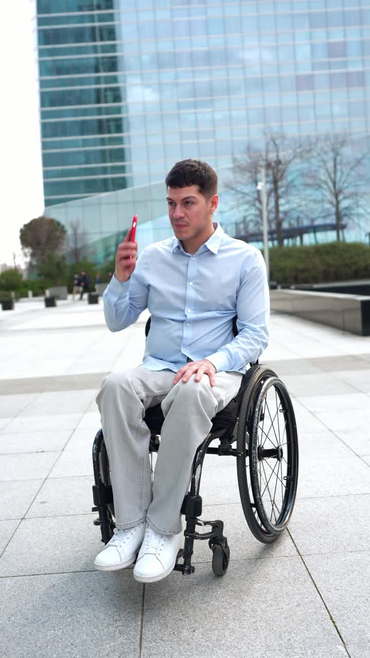 Happy Young Man in Wheelchair Talking on Mobile Phone