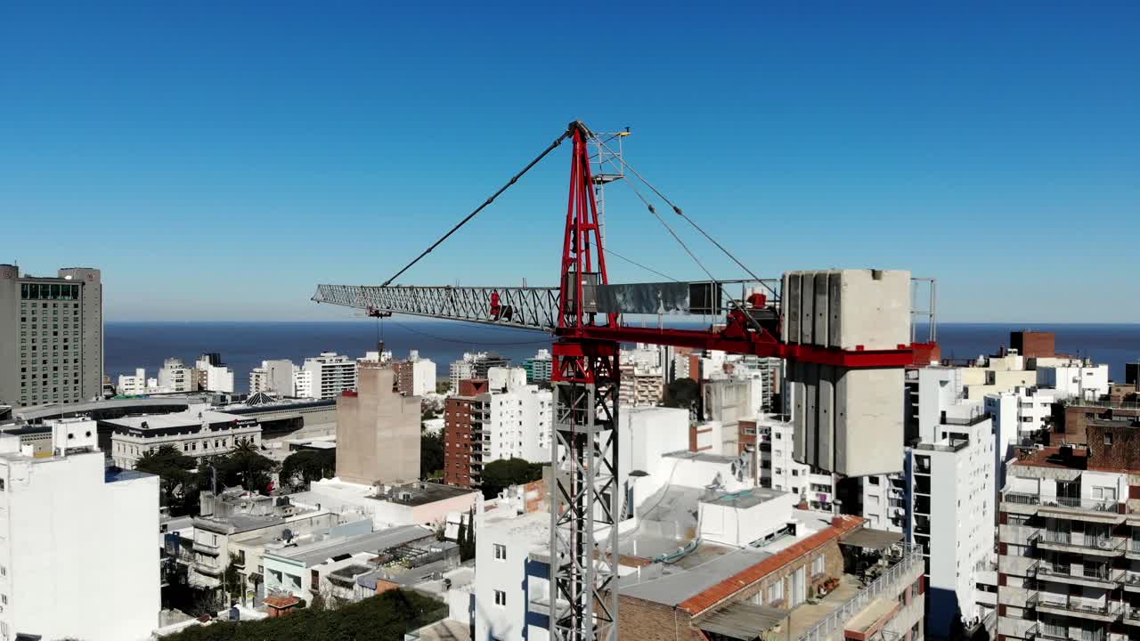 vista aérea de la ciudad de montevideo uruguay, con edificios, un edificio de grúas, el mar y el cielo despejado al fondo