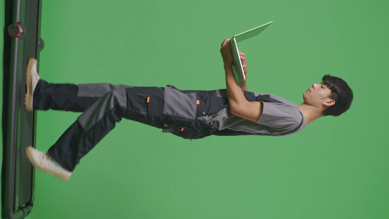 trabajador cargando una computadora portátil en la pantalla verde de la cinta de correr