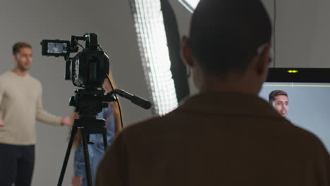 female film director and assistant watching actors shooting movie or video in studio on monitor 7