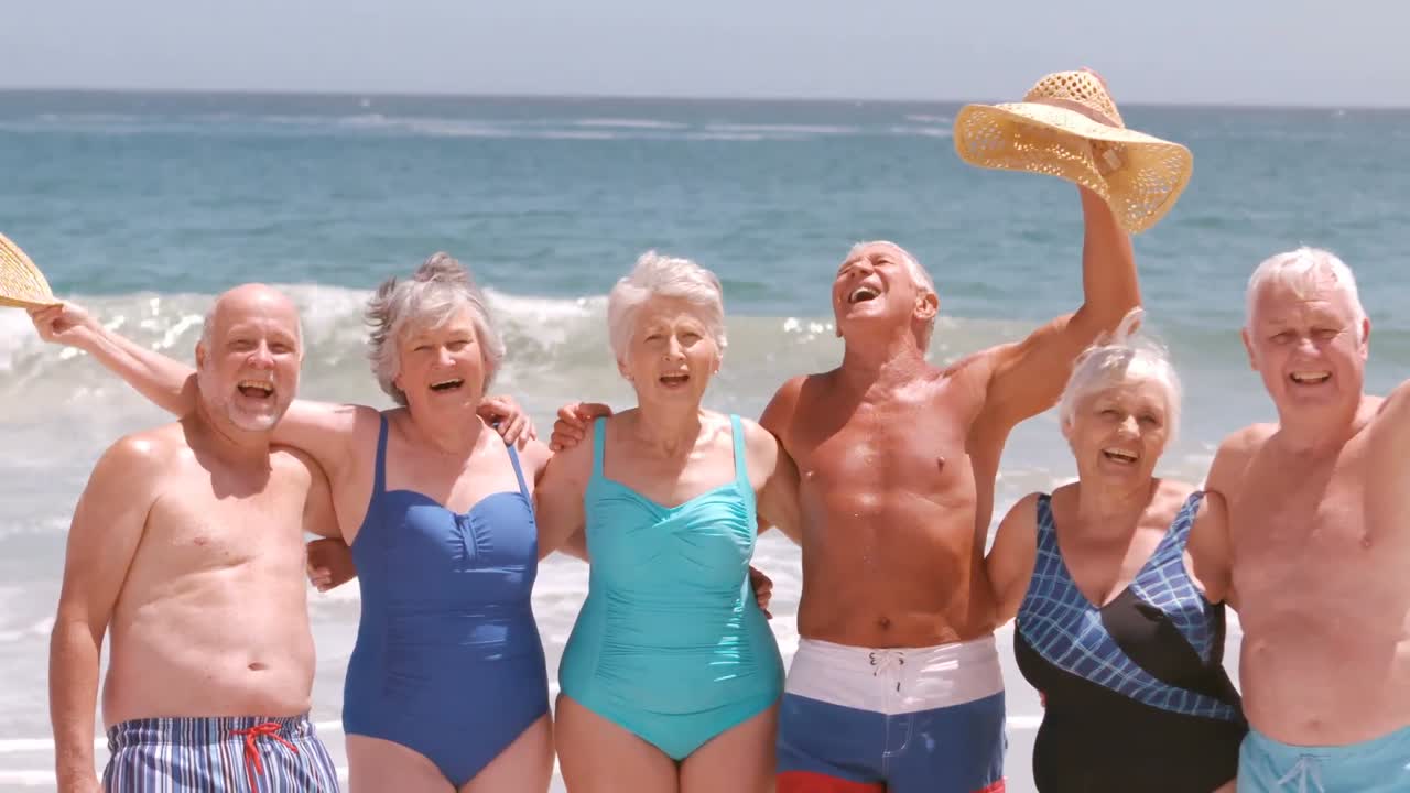 상급 친구 들 이 해변 에서 포즈 를 취 하고 미소 짓고 있다