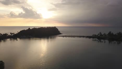 Purple-sunset-over-the-waves-and-tropical-beach-of-South-Goa,-India--aerial