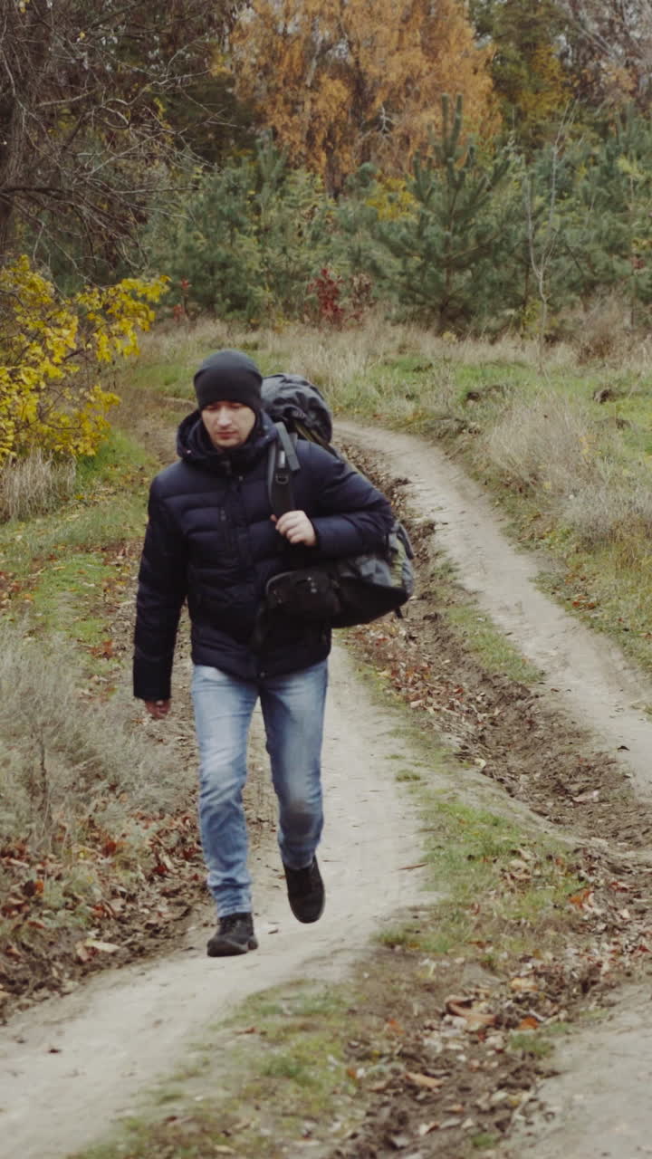 Tourist with backpacks travel. Tourist man with backpack on meadow in autumn forest