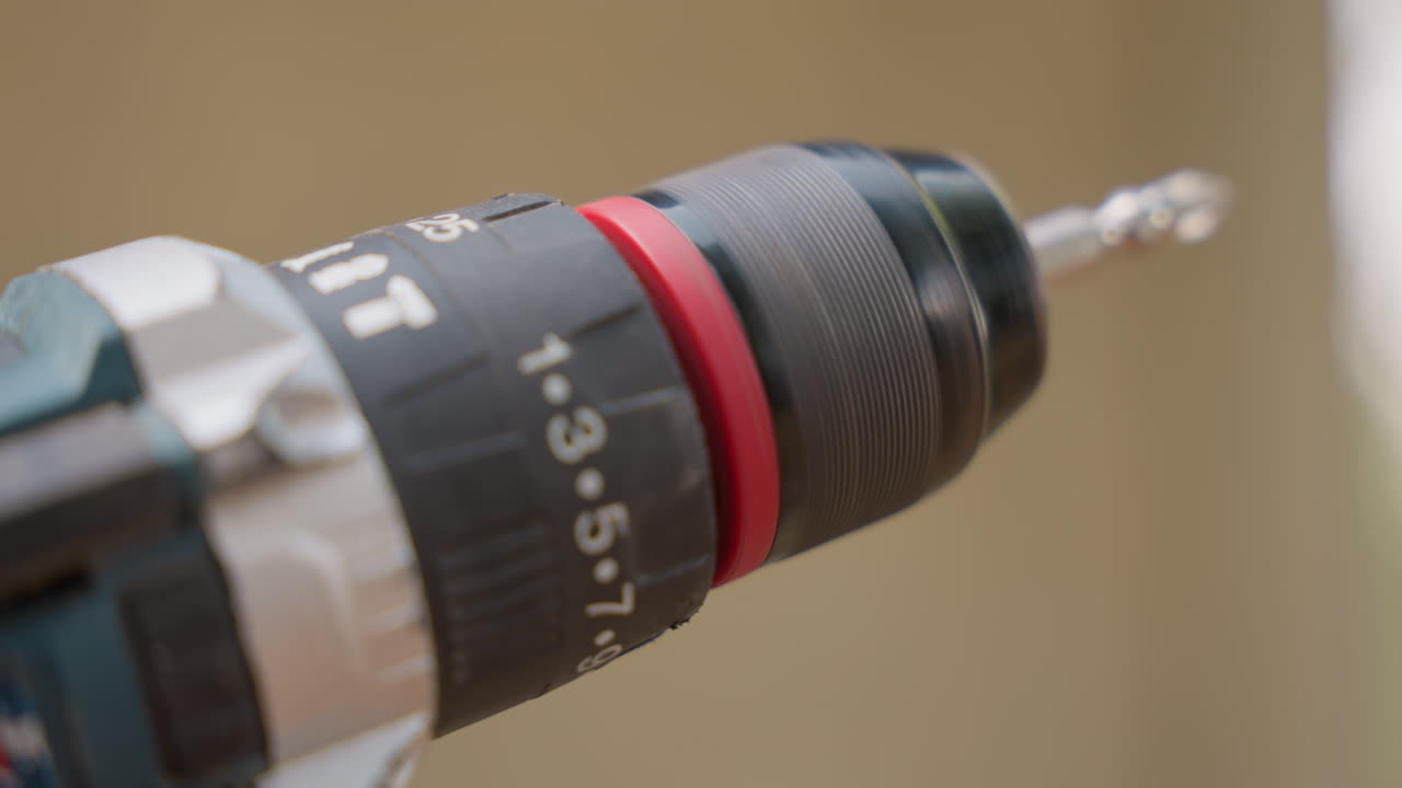 Closeup drill chuck with bit, carpenter drilling pilot hole into timber, soft studio light, shallow depth of field, numeric torque settings visible, steady hand movement, precise carpentry action