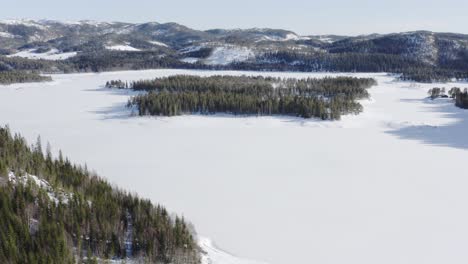 Lago-Congelado-Cubierto-De-Nieve-Con-Bosque-De-Coníferas-Durante-El-Invierno-En-Indre-Fosen,-Noruega