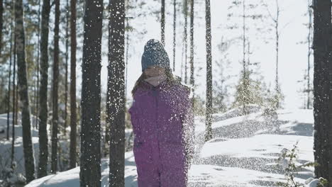 slow motion of happy girl playing with snow in woods on bright day