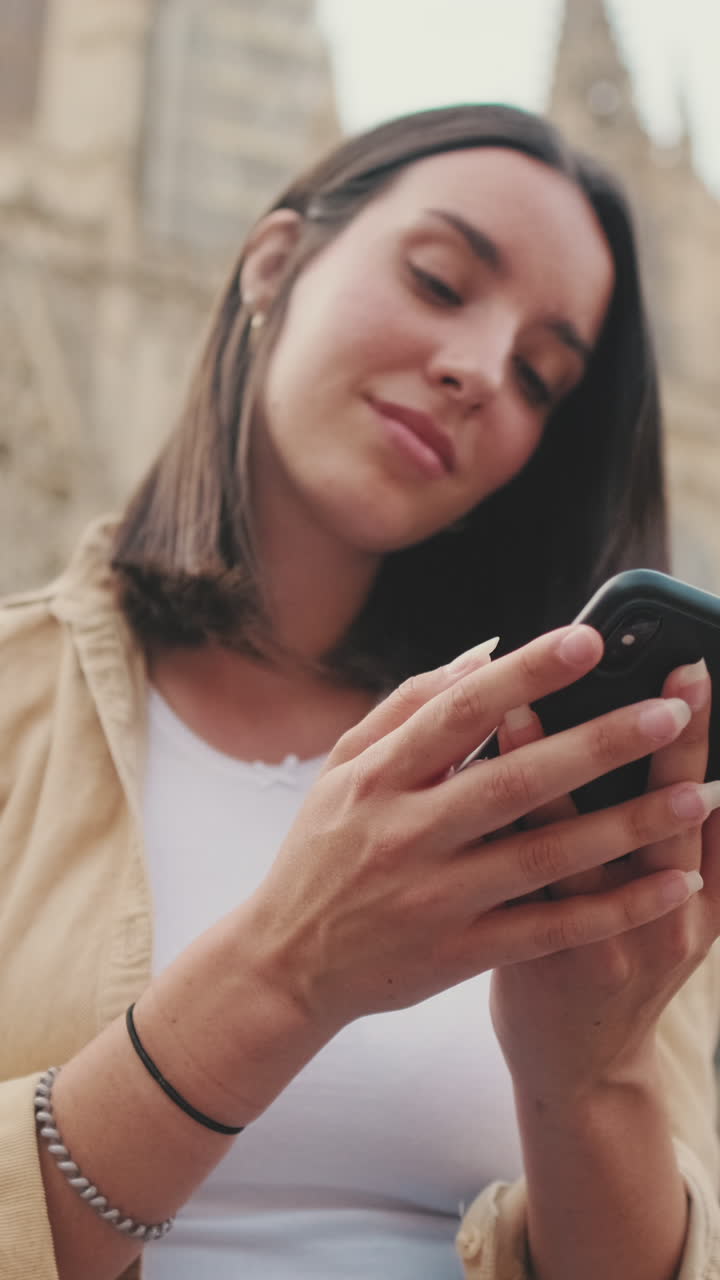 Giovane donna che usa uno smartphone all'aperto in città