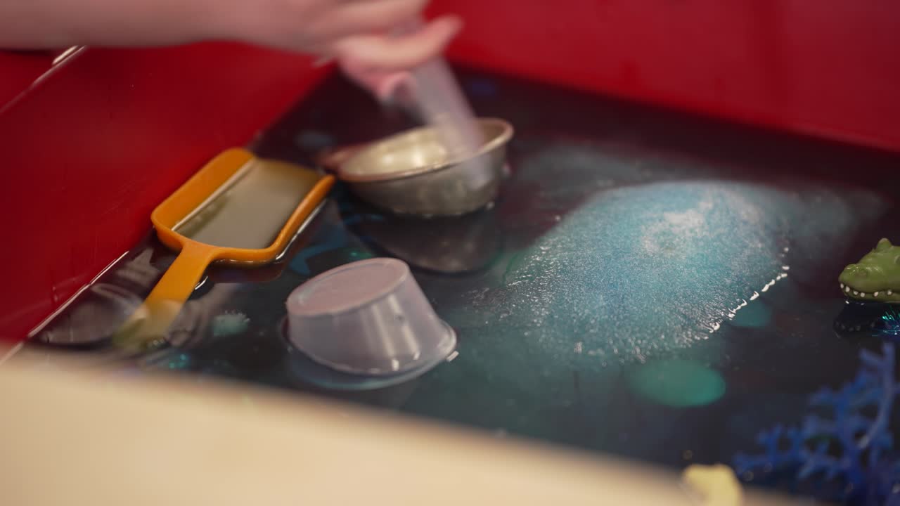 Preschooler's hands playing with toys in water