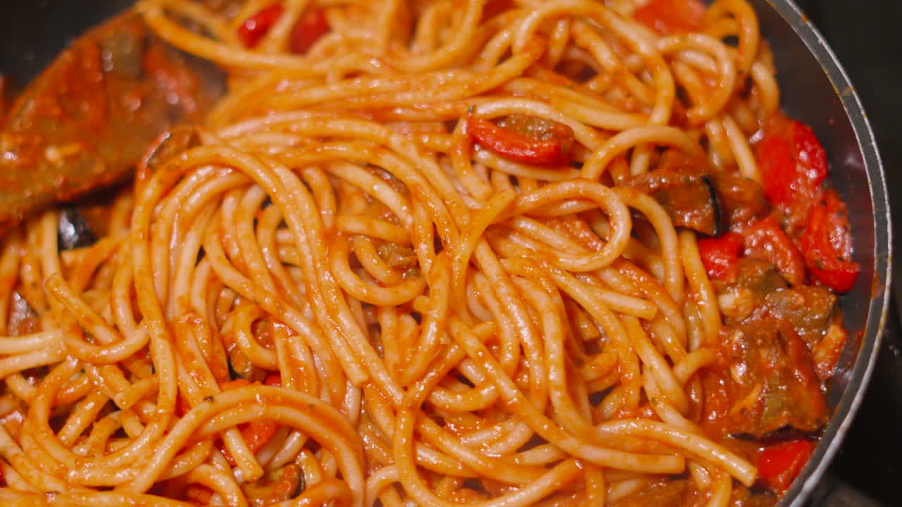 Top View of Italian Tomato Based Pasta Bucatini Spaghetti with Aubergine Egg Plant and Peppers. Delcious Cooking Close Up Food Clip