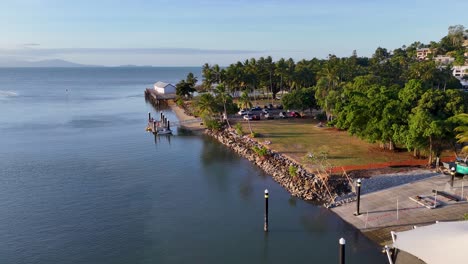 drone captures tranquil marina, palm trees, and calm ocean waters