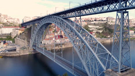 Aerial-view-of-Dom-Luís-I-Bridge-and-Porto-city,-drone-going-forward