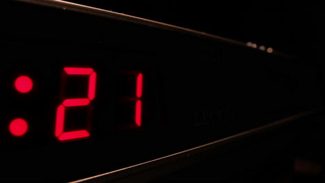 Red-digital-display-clock-counting-down-to-midnight-in-24-hour-time,-timelapse