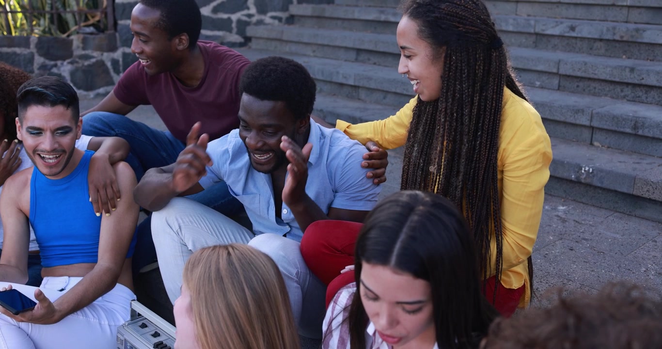 Happy Multi-Ethnic Friends Socializing and Laughing on Steps