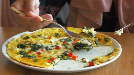 mujer comiendo espinaca y tortilla de queso