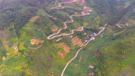 a winding wiggling road cut beautifully into the mountainside on the dong van karst plateau geopark