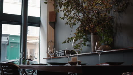 Low-angle-view-of-wine-glasses-kept-on-tables-in-a-typical-French-restaurant-during-a-cloudy-day