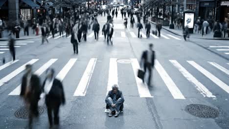 a solitary individual sits on the ground at a crosswalk, surrounded by rushing pedestrians in a bustling metropolitan area. the contrast highlights the social issue of homelessness.