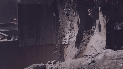 industrial conveyor belt spilling crushed stones in a controlled cascade