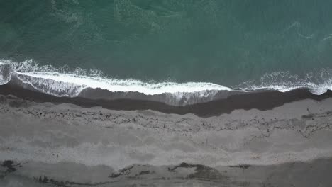 Playa-Islandesa-De-Arena-Negra-Bañada-Por-El-Tranquilo-Océano.