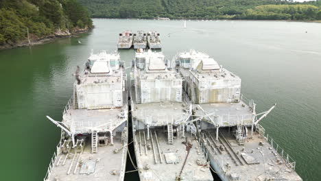 Arc-Aerial-Large-Derelict-Boats-Floating-on-Top-of-Wide-River