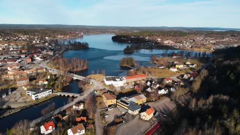 aerial flyover rural city with natural blue lake during golden sunny day