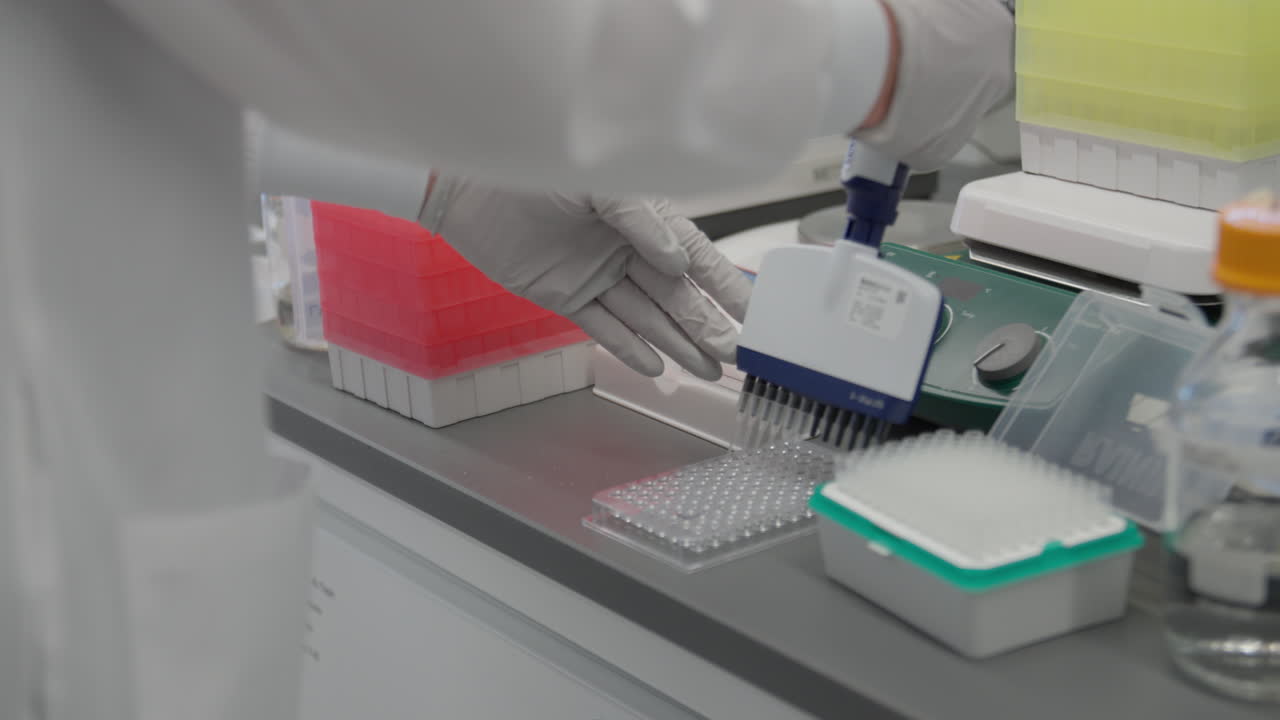 Tight shot of scientist preparing samples with gloved hands