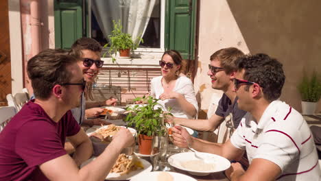 group of friends enjoying a meal outdoors in italy