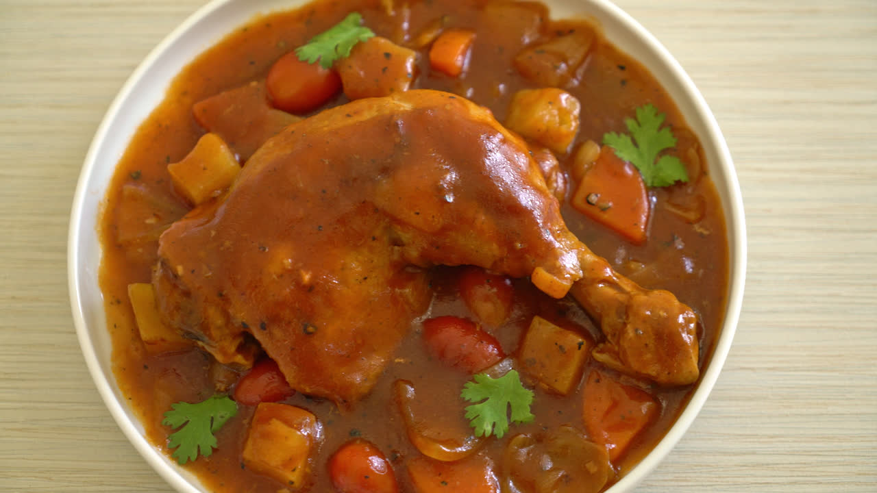 Guiso de pollo casero con tomate, cebolla, zanahoria y patatas en un plato con arroz