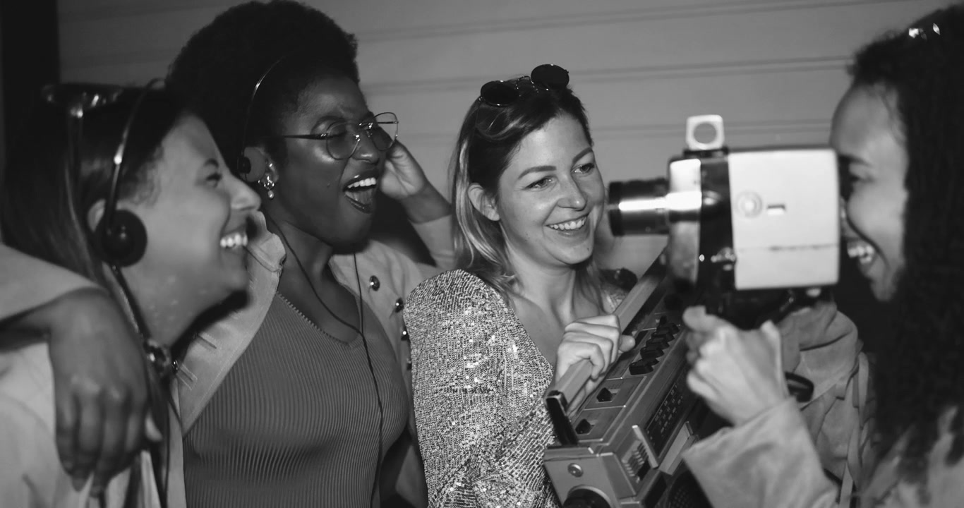 Happy Multi-Ethnic Women Laughing with Vintage Camera and Boombox