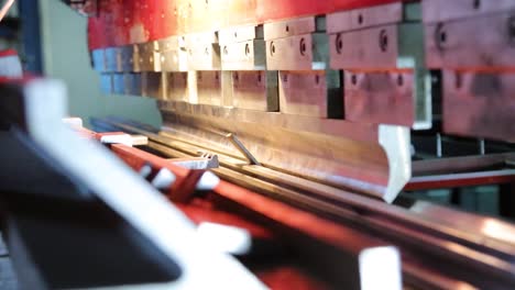 a worker starts a sheet metal bending machine, view from the inside