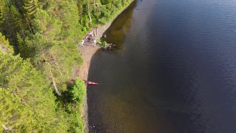 toma de drones de una isla en medio de un lago del norte con un kayak en la orilla