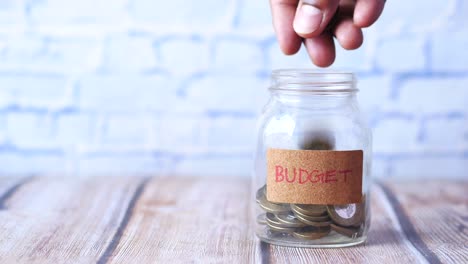 budget text on a saving coins jar on white ,