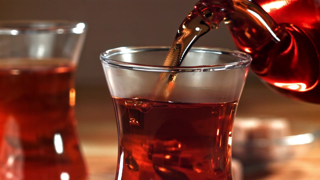 Primo piano di tè rosso versato in un bicchiere tradizionale