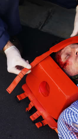 emergency medical technician protecting the head of his wounded person