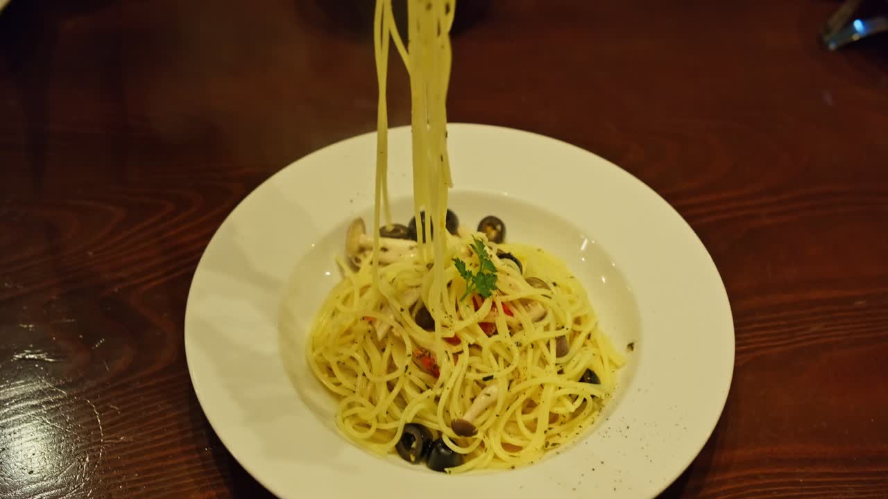 Sharing Spaghetti from Large Plate to Small Dish in Cozy Restaurant, Social Dining Concept