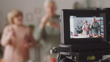 cámara digital grabando vlog culinario de una pareja de ancianos